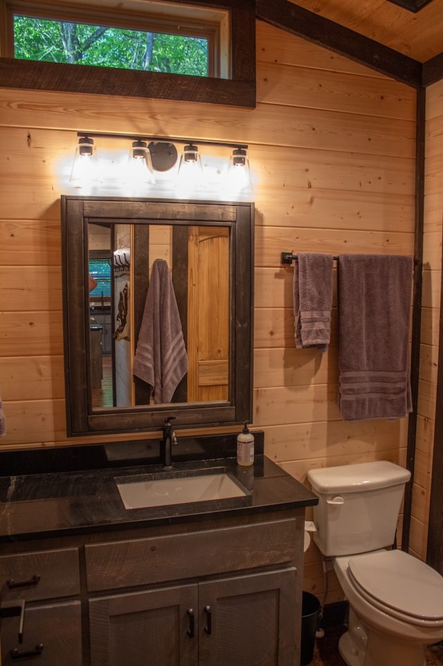 bathroom featuring vanity, lofted ceiling, wooden ceiling, wooden walls, and toilet