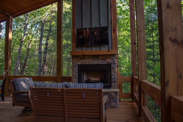 wooden terrace with an outdoor stone fireplace