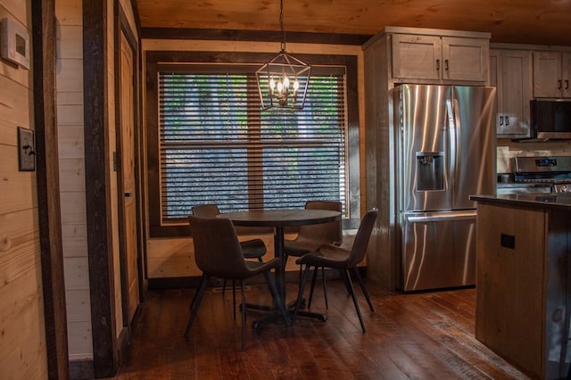 dining space featuring wood ceiling, dark wood-type flooring, wooden walls, and a chandelier