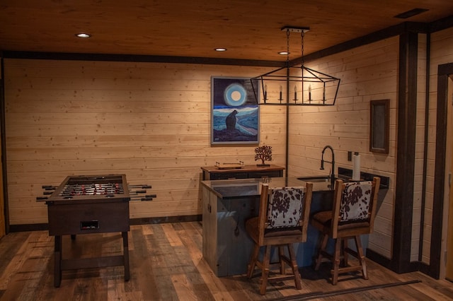 bar featuring dark hardwood / wood-style flooring, pendant lighting, a chandelier, wooden walls, and wood ceiling