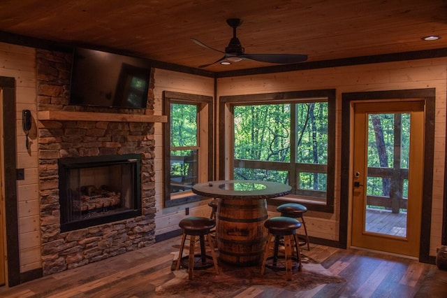 interior space featuring ceiling fan, wooden ceiling, a fireplace, and indoor bar