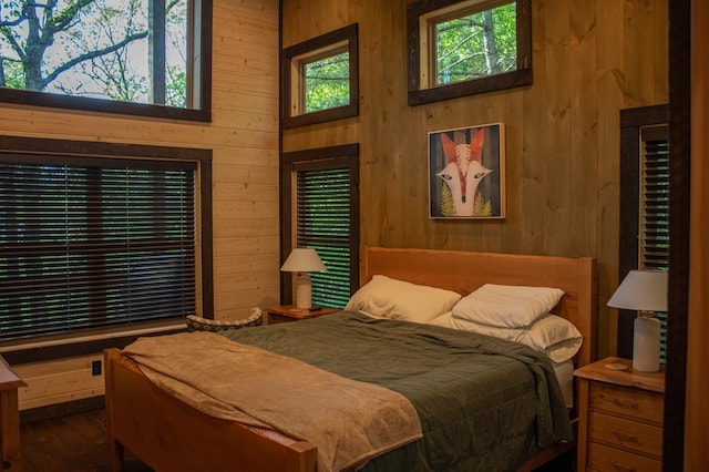 bedroom with wood walls and hardwood / wood-style floors