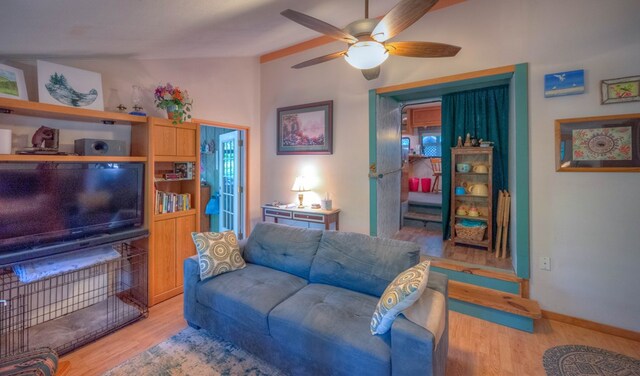 living room with lofted ceiling, ceiling fan, a wealth of natural light, and light wood-type flooring