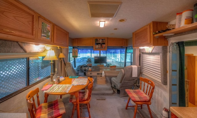 dining area featuring a textured ceiling and light colored carpet