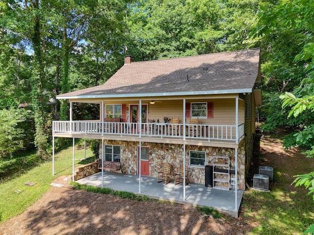 view of front of home with a balcony, central AC unit, and a patio area