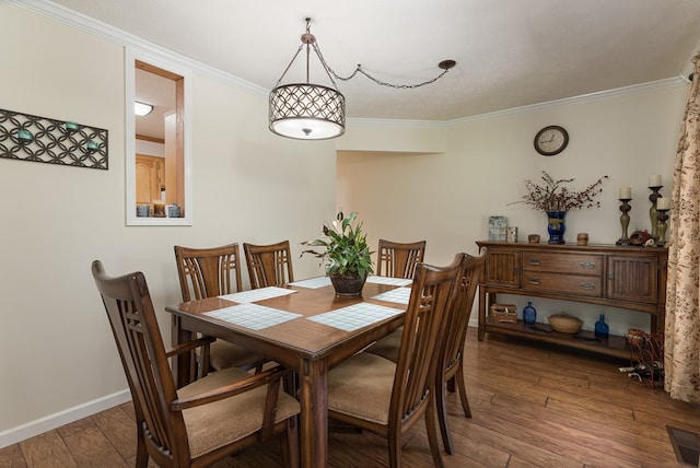 dining area with dark wood-type flooring and ornamental molding