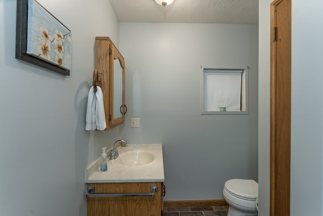 bathroom featuring vanity, tile patterned floors, a textured ceiling, and toilet