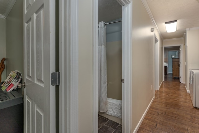 hallway featuring washer and clothes dryer, dark wood-type flooring, a textured ceiling, and crown molding