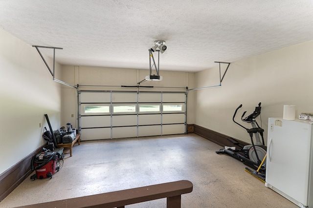 garage featuring a garage door opener and white refrigerator