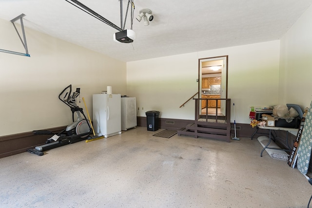 garage with a garage door opener and white refrigerator