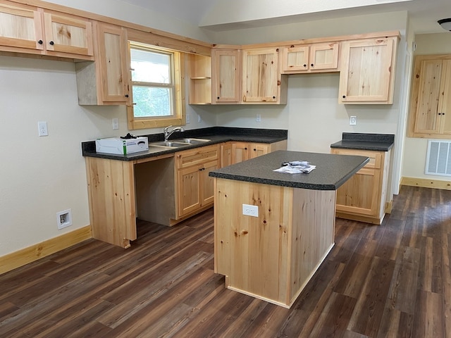 kitchen with light brown cabinetry, sink, a kitchen island, and dark hardwood / wood-style floors