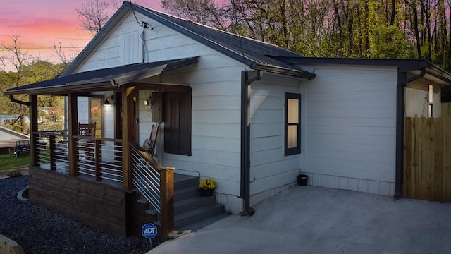 view of front of home with covered porch and fence