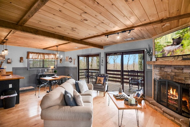 living room featuring wood finished floors, wood ceiling, a fireplace, and wainscoting