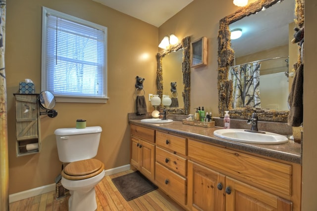 bathroom with wood finished floors, a shower with shower curtain, a sink, and toilet