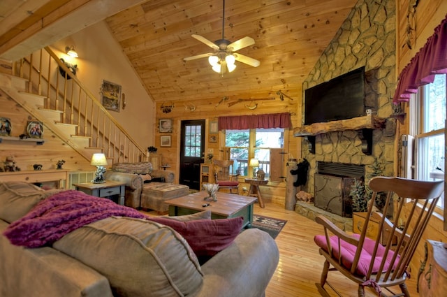 living area featuring a fireplace, high vaulted ceiling, wooden ceiling, hardwood / wood-style floors, and stairs