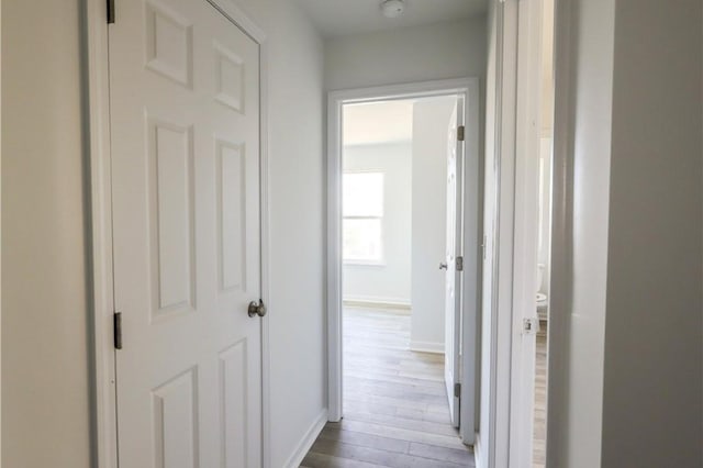 hall featuring wood finished floors and baseboards
