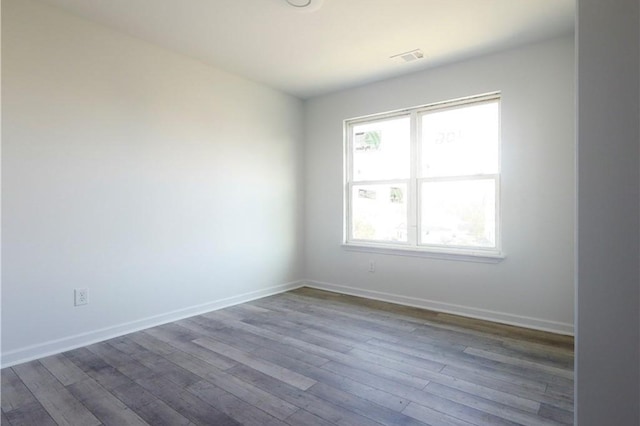 empty room featuring wood finished floors and baseboards