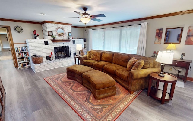 living room with ceiling fan, ornamental molding, a fireplace, and hardwood / wood-style floors