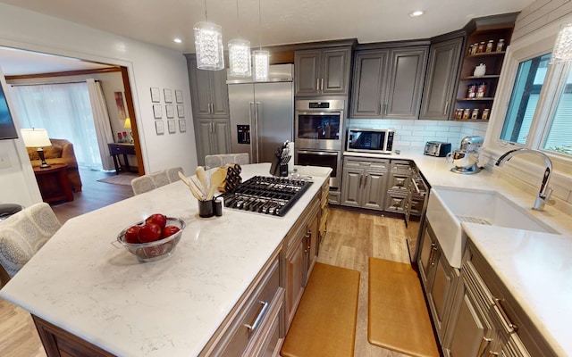 kitchen with light stone counters, a kitchen bar, stainless steel appliances, and a kitchen island