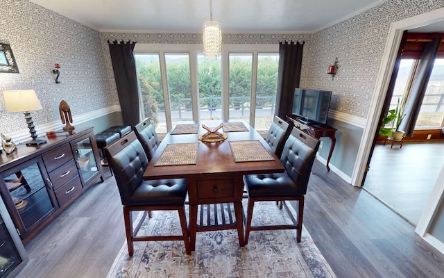 dining space with wood-type flooring and crown molding