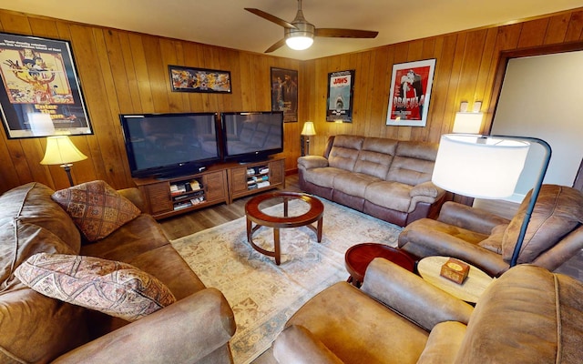 living room with wooden walls, hardwood / wood-style floors, and ceiling fan