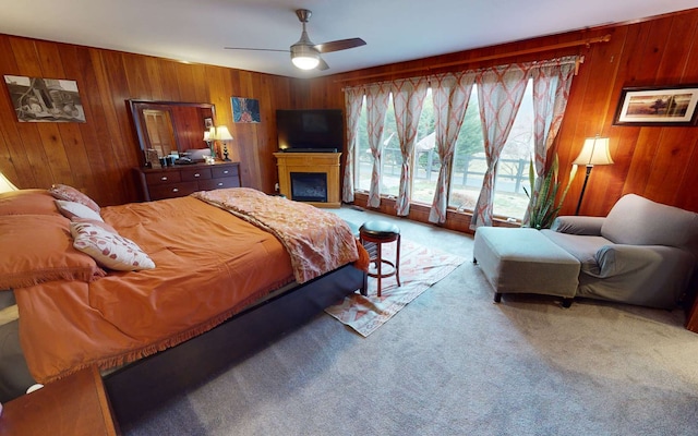 bedroom with carpet flooring, ceiling fan, and wood walls