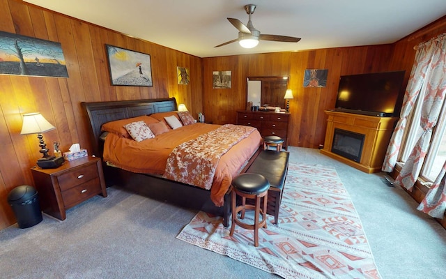 carpeted bedroom with wooden walls and ceiling fan