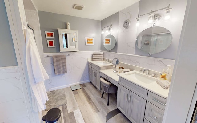 bathroom with tile walls, hardwood / wood-style floors, and vanity