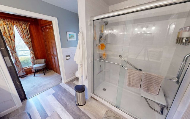 bathroom with wood-type flooring and a shower with door