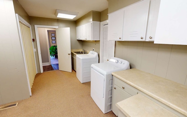 washroom featuring sink, washer and clothes dryer, and cabinets