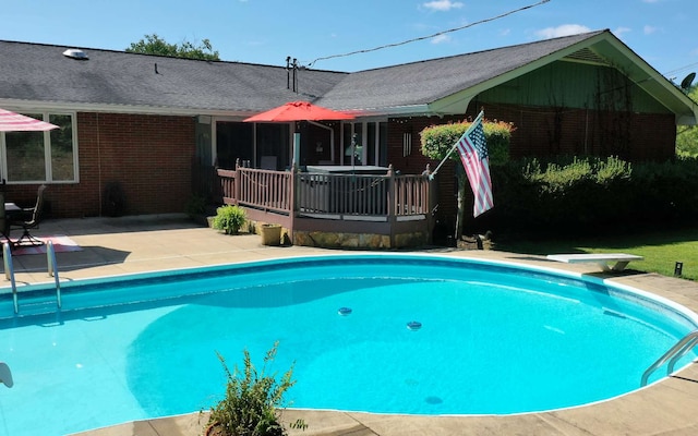 view of swimming pool with a wooden deck and a patio