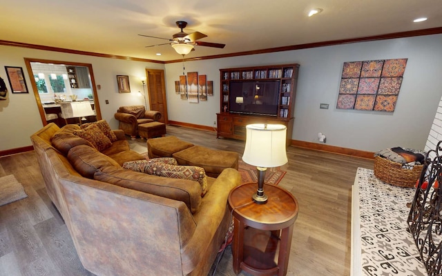 living room featuring ceiling fan, ornamental molding, and wood-type flooring