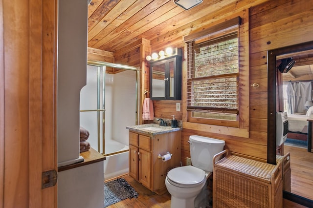 full bathroom with hardwood / wood-style floors, wood walls, toilet, shower / bath combination with glass door, and wooden ceiling