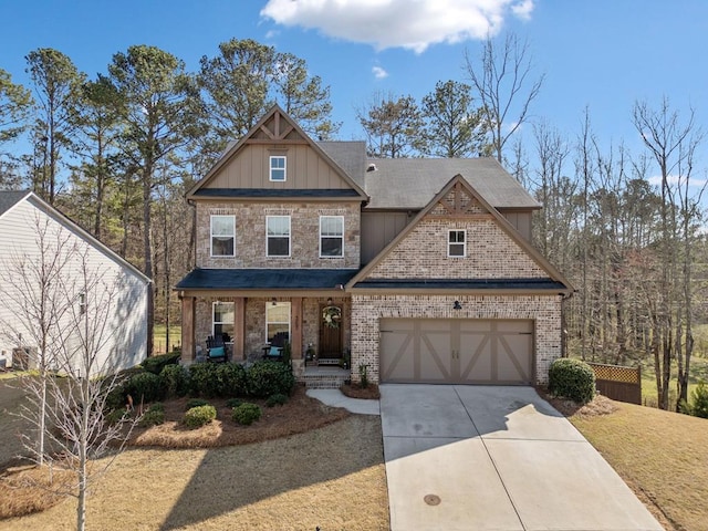 view of front of property with brick siding, an attached garage, board and batten siding, covered porch, and driveway