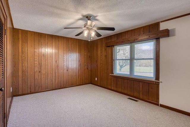 2915 Airport Rd, Marble, NC 28905 - carpeted empty room featuring a textured ceiling, visible vents, a ceiling fan, and wood walls