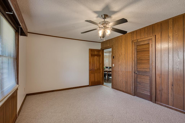 2915 Airport Rd, Marble, NC 28905 - unfurnished bedroom with a closet, a textured ceiling, crown molding, wooden walls, and carpet floors