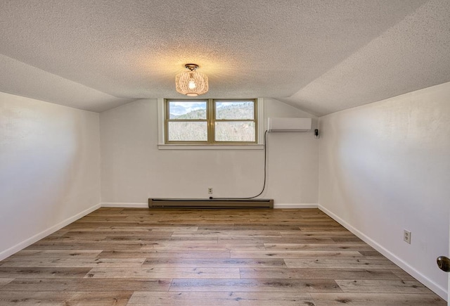 2915 Airport Rd, Marble, NC 28905 - bonus room with a wall mounted air conditioner, a textured ceiling, hardwood / wood-style flooring, and a baseboard radiator