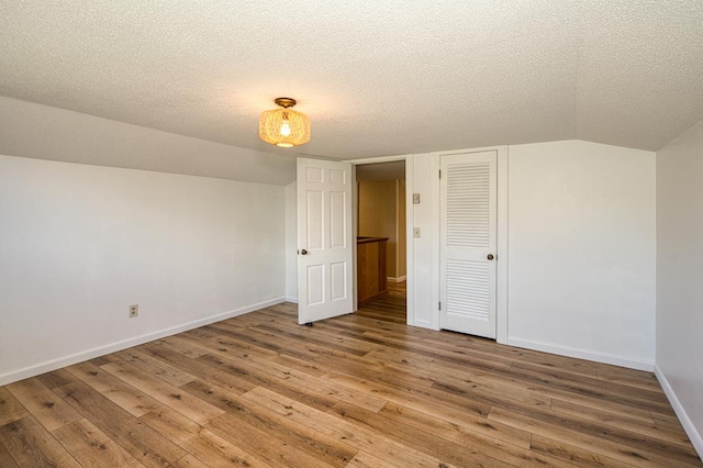 2915 Airport Rd, Marble, NC 28905 - bonus room featuring wood-type flooring, baseboards, vaulted ceiling, and a textured ceiling