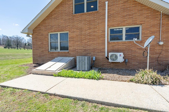 2915 Airport Rd, Marble, NC 28905 - rear view of property featuring ac unit, brick siding, central AC, and a yard