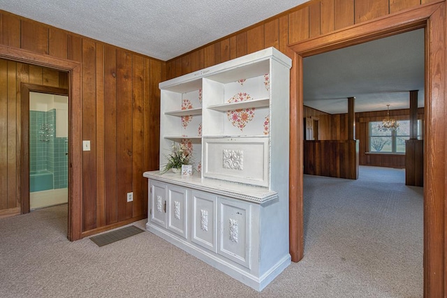 2915 Airport Rd, Marble, NC 28905 - hallway with a textured ceiling, wooden walls, a chandelier, and carpet