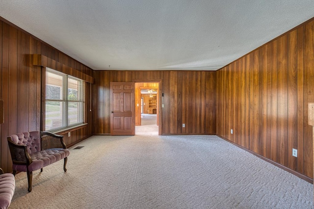 2915 Airport Rd, Marble, NC 28905 - sitting room featuring wood walls, a textured ceiling, visible vents, and light colored carpet