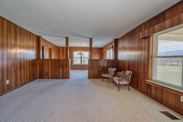 2915 Airport Rd, Marble, NC 28905 - living area with wood walls, a chandelier, a textured ceiling, carpet floors, and visible vents