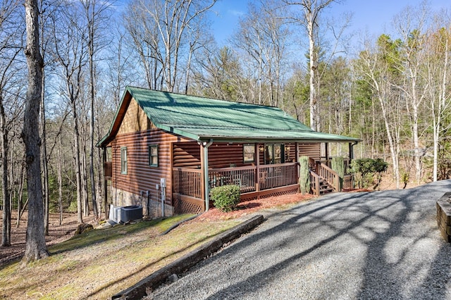 30 The Forest Rd, Blue Ridge, GA 30513 - view of front of home featuring a porch, faux log siding, central AC, metal roof, and a wooded view