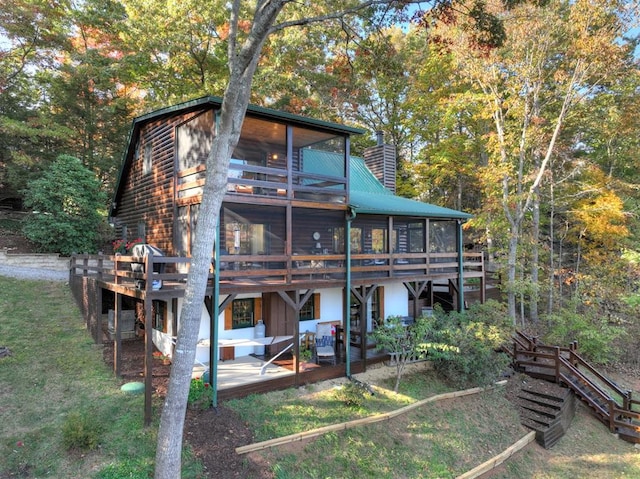 back of house with a patio area, a lawn, a sunroom, and a deck