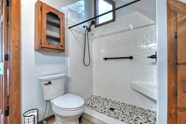 bathroom with toilet and a tile shower