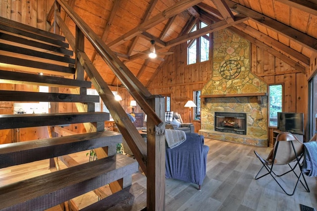 living room with beam ceiling, hardwood / wood-style floors, a healthy amount of sunlight, and a fireplace