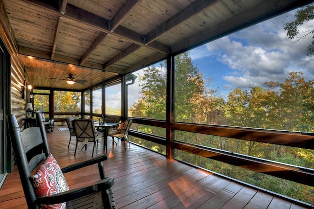 unfurnished sunroom with beamed ceiling, wood ceiling, and ceiling fan