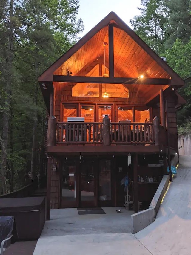 rear view of property featuring a hot tub