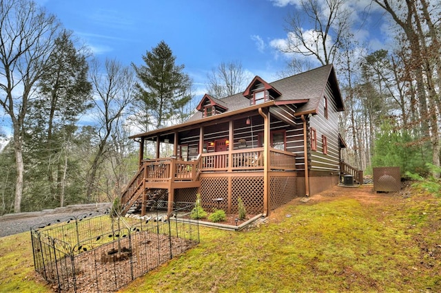 view of front of home with a deck and a front lawn