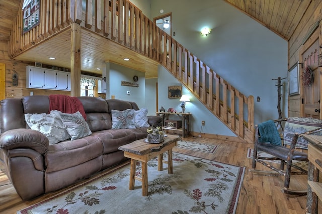 living room featuring wood ceiling, a high ceiling, and light wood-type flooring